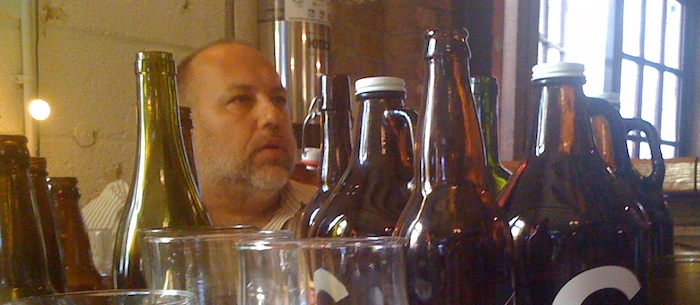 Jimmy Carbone, Good Beer Seal co-founder, surrounded by beer bottles during 2010 interview